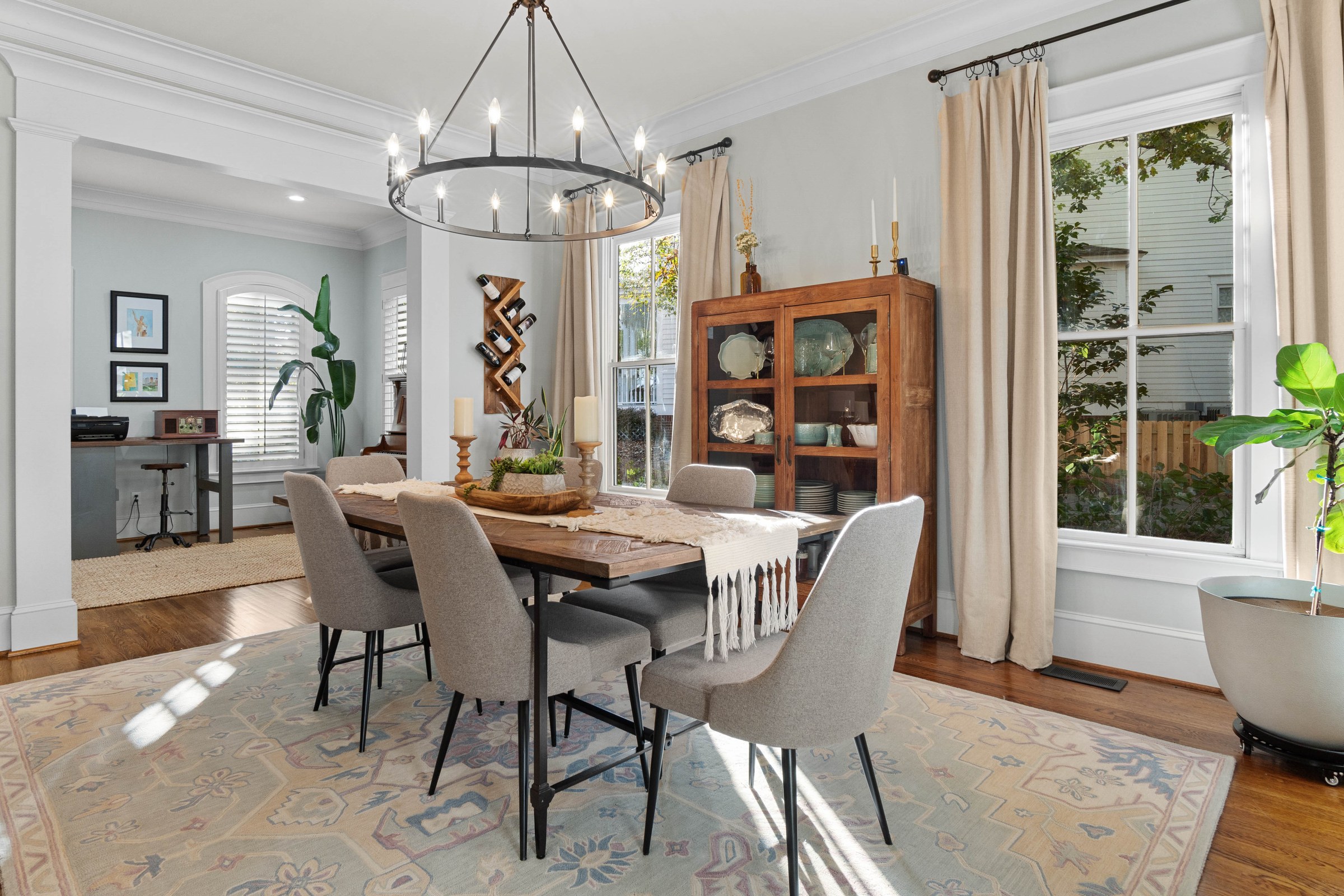 Formal dining room with a sculptural chandelier, framed artwork, and French doors to the yard
